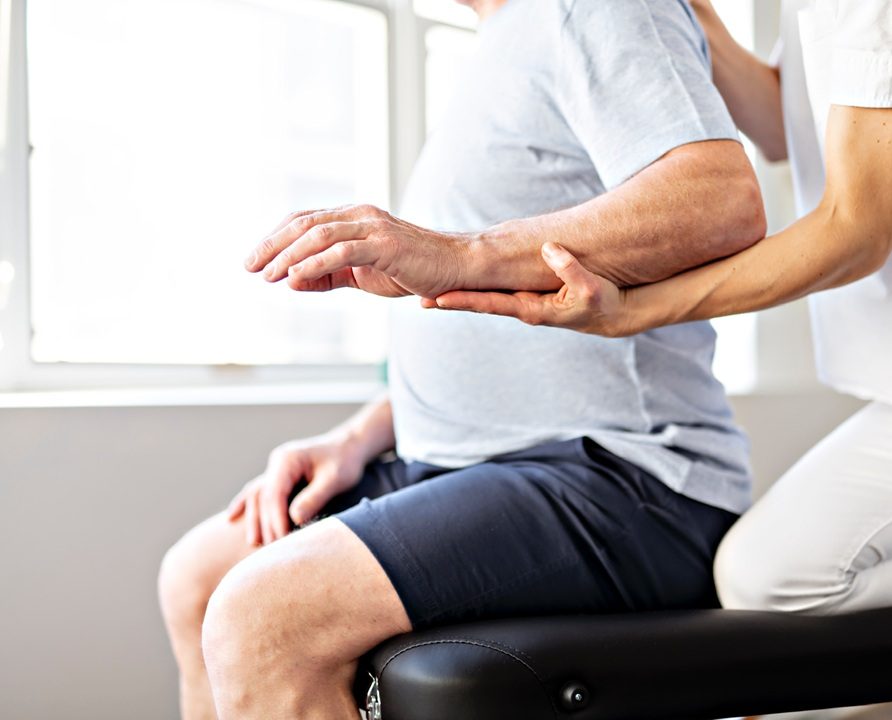 Modern rehabilitation physiotherapy worker with senior client